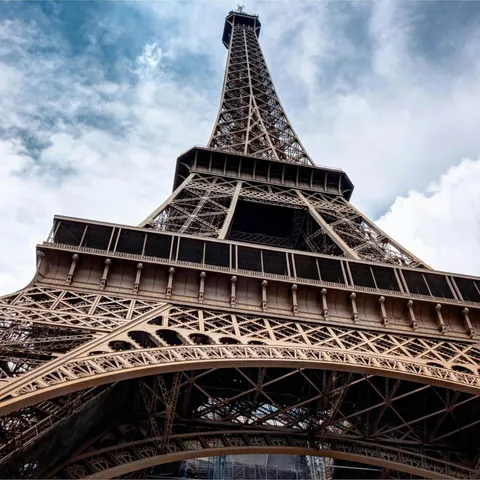 Torre Eiffel vista desde su base hacia el cielo nublado en París, Francia