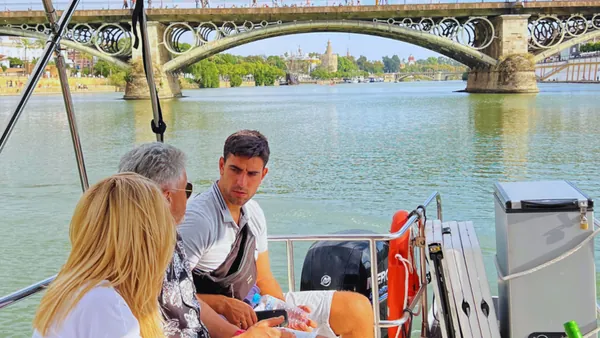 Vista panorámica desde el barco con uno de los puentes emblemáticos de fondo.