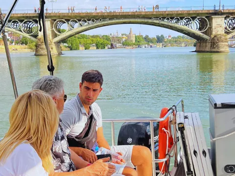 Vista panorámica desde el barco con uno de los puentes emblemáticos de fondo.