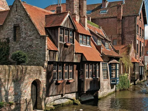 Excursionistas en un paseo en barca por los canales de Brujas, Bélgica