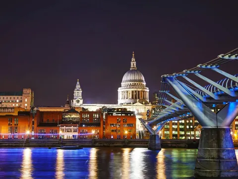 Catedral de San Pablo y Millennium Bridge iluminados de noche en Londres.