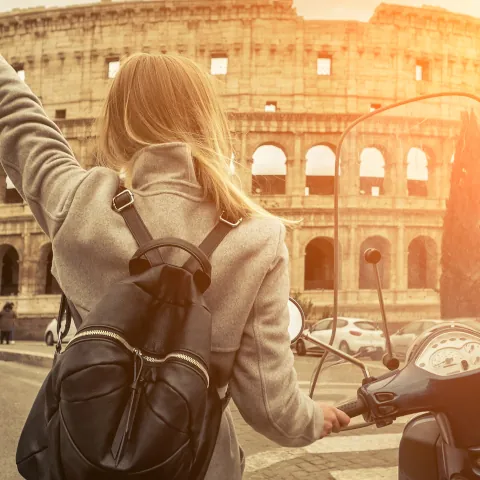 Mujer con la moto frente al Coliseo de Roma