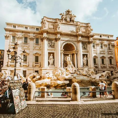 Fontana di Trevi en Roma con turistas y puestos callejeros en la plaza