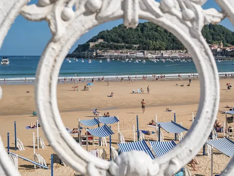 Vista de la playa de La Concha en San Sebastián enmarcada por la barandilla blanca.