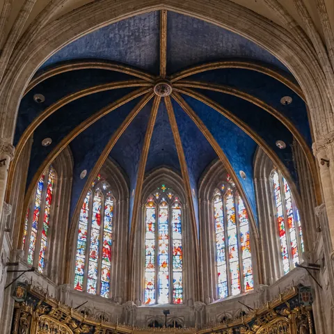 Interior de la Catedral de Oviedo, con su impresionante bóveda azul estrellada y vidrieras góticas llenas de color.