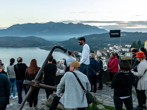 Turistas con guía de buendía en el mirador de San Roque en Lastres con vistas a la costa.