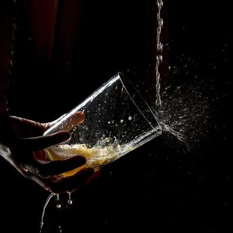 Mano sujetando un vaso mientras se escancia sidra en el