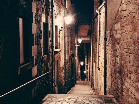 Callejón estrecho y oscuro del Old Town de Edimburgo por la noche