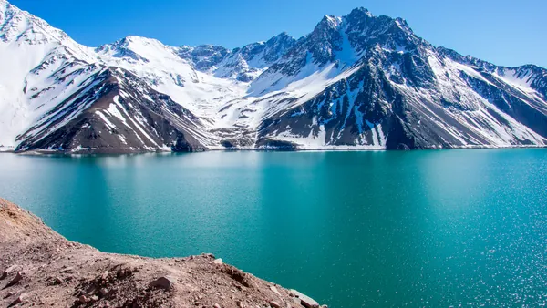 Aguas turquesas del Embalse de Yeso con las montañas de fondo.