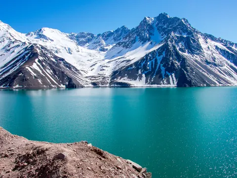 Aguas turquesas del Embalse de Yeso con las montañas de fondo.