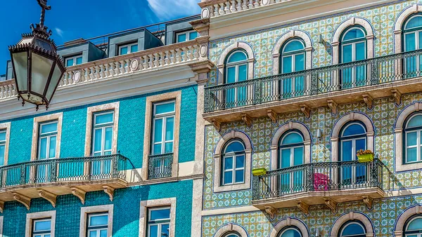 Fachadas de Lisboa decoradas con coloridos azulejos y balcones de hierro forjado.