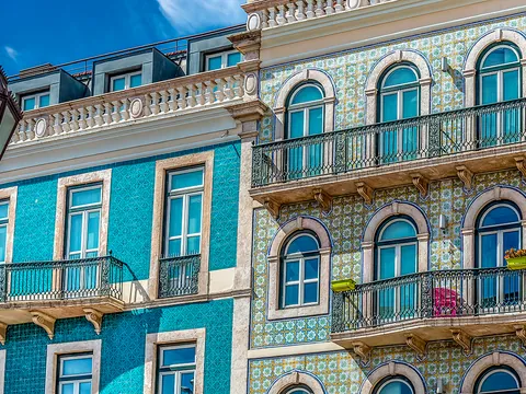 Fachadas de Lisboa decoradas con coloridos azulejos y balcones de hierro forjado.