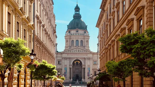 La Basílica de San Esteban en Budapest vista desde una calle arbolada.