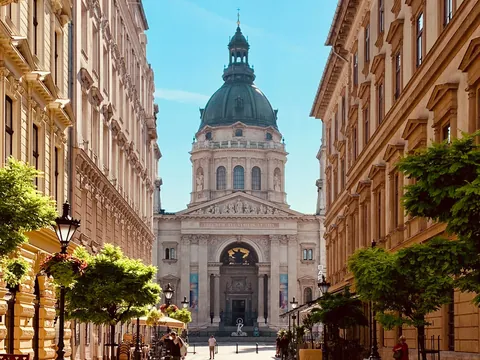 La Basílica de San Esteban en Budapest vista desde una calle arbolada.
