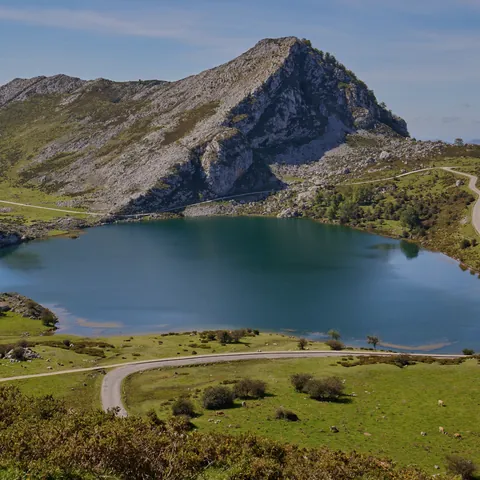 Vista aérea del Lago Enol, Lagos de Covadonga en Picos de Europa, Asturias, con montañas y carretera.