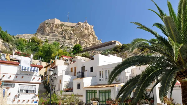 Casas blancas del barrio de Santa Cruz con vista al castillo de Santa Bárbara en Alicante