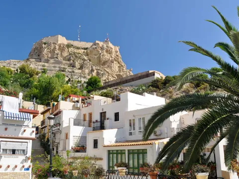 Casas blancas del barrio de Santa Cruz con vista al castillo de Santa Bárbara en Alicante