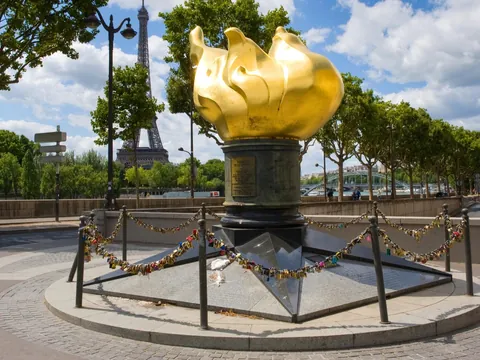 Llama de la Libertad con candados y la Torre Eiffel al fondo en París