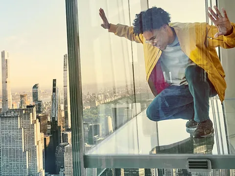 Joven en la plataforma de observación del Summit One Vanderbilt con la ciudad en el horizonte