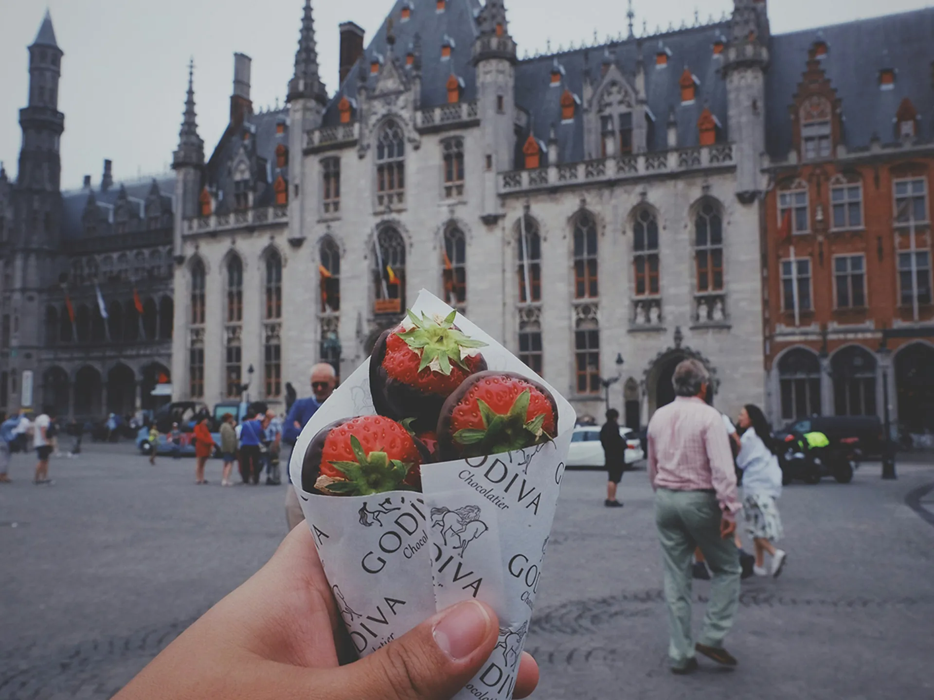 Cono de fresas con chocolate Godiva frente al Ayuntamiento de Brujas, Bélgica