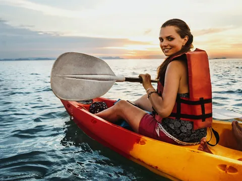 Mujer en kayak durante el atardecer en Es Grau, Menorca