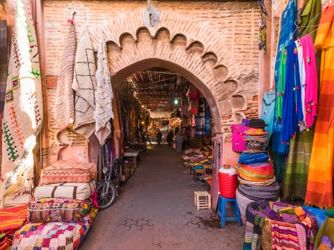 Calle comercial de la Medina de Marrakech con alfombras y puestos tradicionales