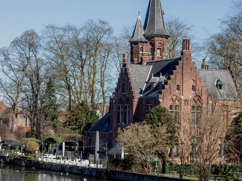 Castillo Waalbrug con torres junto al canal Minnewater de Brujas, Bélgica.