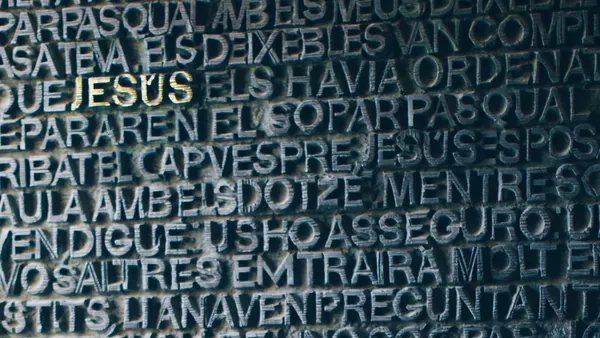 Puerta de bronce de la Sagrada Familia con relieve de texto en Barcelona.