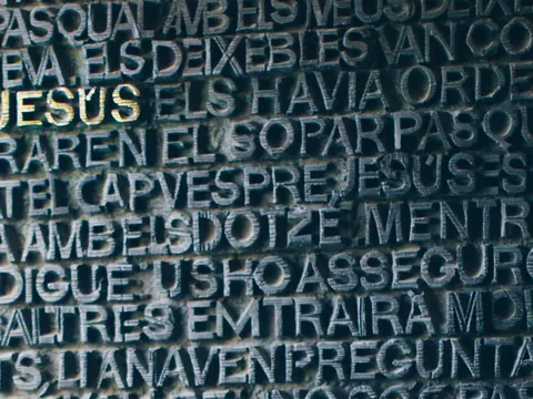 Puerta de bronce de la Sagrada Familia con relieve de texto en Barcelona.