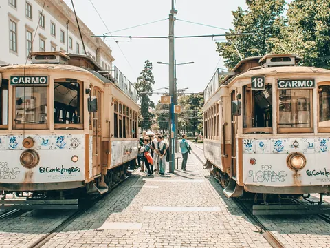 Dos tranvías históricos de Oporto en la línea de Carmo con gente a su alrededor.