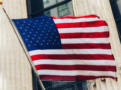 Bandera de Estados Unidos ondeando en Wall Street, Nueva York, Estados Unidos