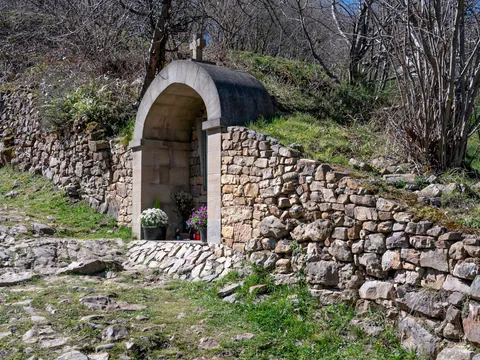 Pequeña capilla o altar de piedra en San Sebastián de Garabandal, Cantabria, situada junto al camino empedrado