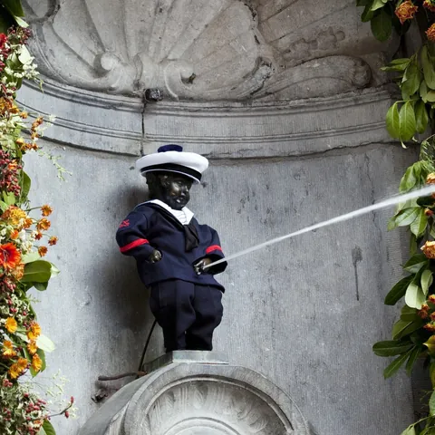 Estatua de bronce Manneken Pis en Bruselas con traje