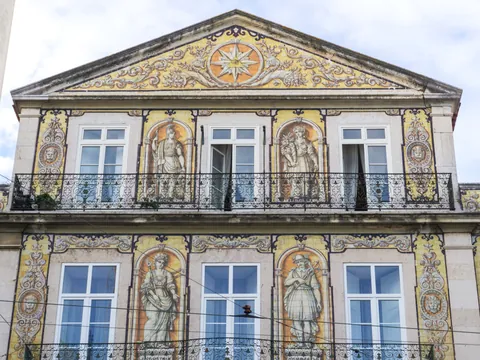 Fachada histórica de Lisboa decorada con azulejos figurativos tradicionales.