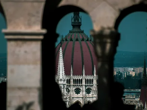 Cúpula del Parlamento enmarcada desde los arcos del Bastión de los Pescadores en Budapest