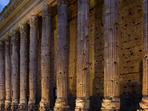 Columnas iluminadas del Templo de Adriano al anochecer en la plaza de Piedra, Roma.