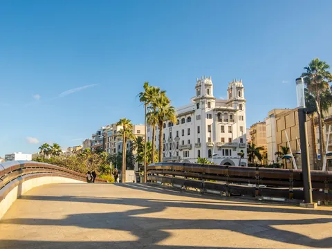 Puente urbano con palmeras y edificio histórico en el centro de Ceuta