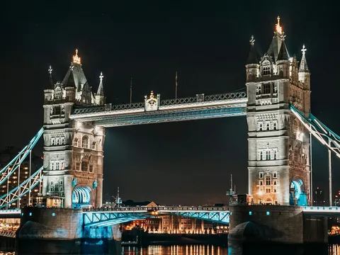 Puente de la Torre de Londres iluminado de noche sobre el río Támesis.
