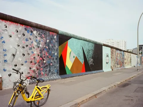 Murales de la East Side Gallery del Muro de Berlín con una bicicleta amarilla en primer plano