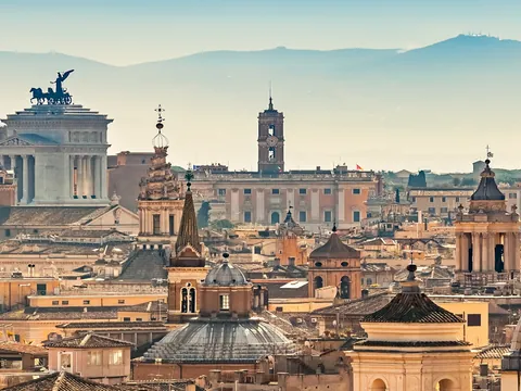 Panorámica de Roma con cúpulas históricas y el Altar de la Patria al fondo.