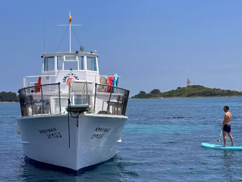 Chico disfruta del paddle surf en la bahía de Alcúdia, Mallorca