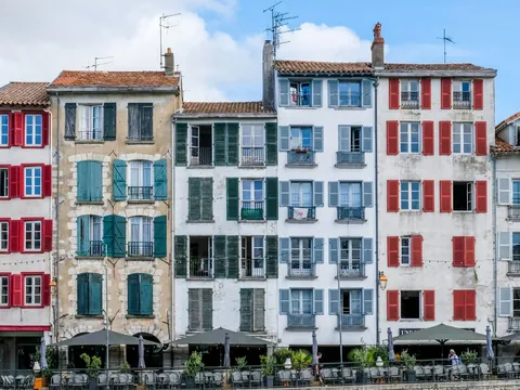 Fachadas con contraventanas de colores en Bayona junto al paseo del río.
