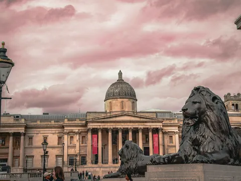 Trafalgar Square Londres con leones de bronce, National Gallery y cielo rosado al atardecer