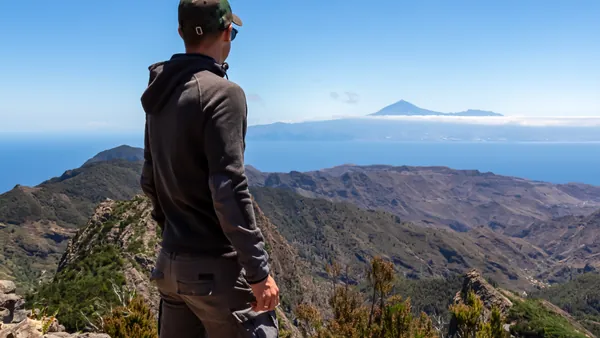 Senderista observando el paisaje desde las alturas.