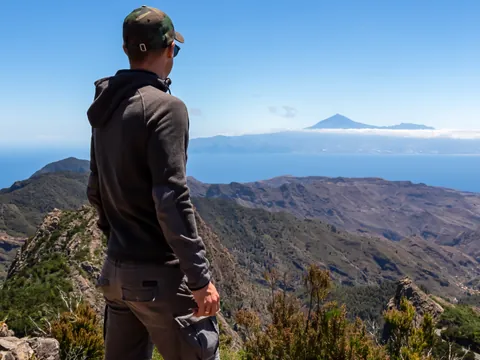 Senderista observando el paisaje desde las alturas.