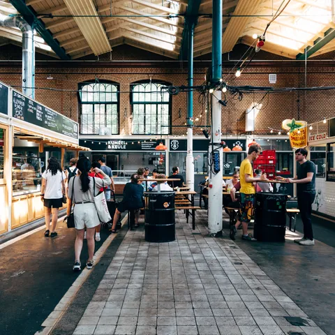 Puestos con clientes en el interior del Marheineke Markthalle de Berlín - JJFarq / Shutterstock.com