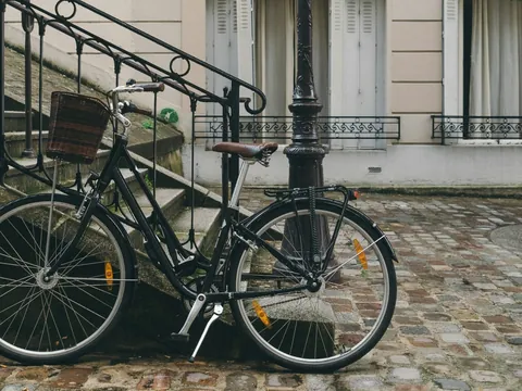 Bicicleta clásica apoyada en una escalera de piedra en Montmartre, París