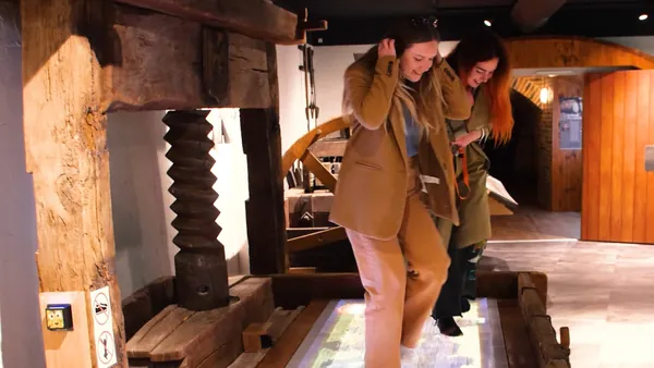 Chicas divirtiéndose en el Museo del vino de Alsacia con los pies descalzos.