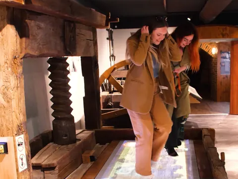Chicas divirtiéndose en el Museo del vino de Alsacia con los pies descalzos.