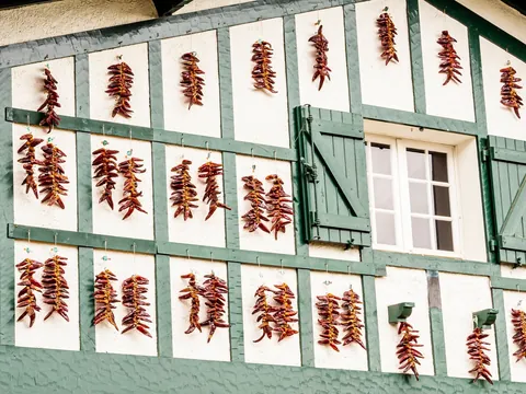 Fachada típica de Espelette decorada con pimientos rojos secándose, símbolo del País Vasco francés.